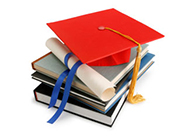 pile of books, a graduation cap and diploma sit on top